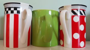 three mugs, red and white, green in the middle